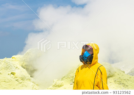 woman volcanologist with a geological hammer and in a respirator against the backdrop of a smoking fumarole on the slope of a volcano woman volcanologist with a geological hammer and in a respirator against the backdrop of a smoking fumarole on the slope of a volcano 93123562