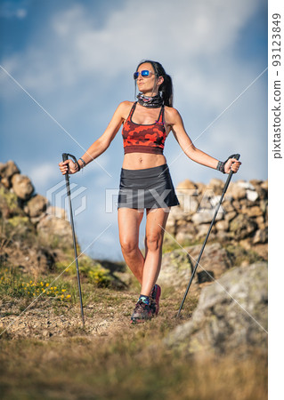 A girl uses poles during a hike 93123849