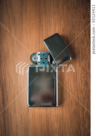 Old vintage lighter on a wooden background Old vintage lighter on a wooden background 93124411