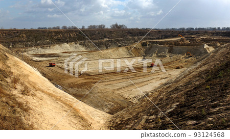 Excavators extracts the clay into open industrial quarry under cloudy sky Excavators extracts the clay into open industrial quarry under cloudy sky 93124568