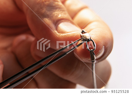 Closeup hands of jeweler at work in jewelry. Desktop for craft jewelry making with professional tools. Closeup hands of jeweler at work in jewelry. Desktop for craft jewelry making with professional tools. 93125528