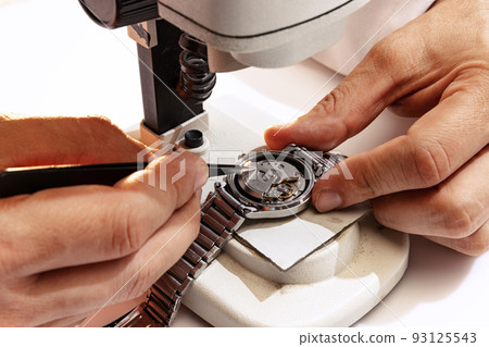 Closeup watchmaker's hands repairing mechanical watches isolated over white background. Concept of vintage retro mechanisms, job, work, ad Closeup watchmaker's hands repairing mechanical watches isolated over white background. Concept of vintage retro mechanisms, job, work, ad 93125543