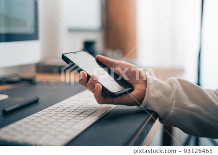 Man working on computer desk at home office 93126465