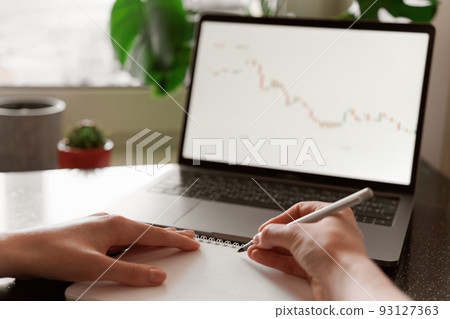Female hands writing down numbers from laptop. Investment analysis, trading concept. Technology, digitalization, cryptocurrency, exchange market, working from home theme. World crysis, graph decline Female hands writing down numbers from laptop. Investment analysis, trading concept. Technology, digitalization, cryptocurrency, exchange market, working from home theme. World crysis, graph decline 93127363