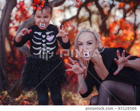 Young girl in black cat costume goes trick or treating 93128566