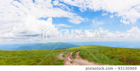 hiking trail through grassy hills. mountain scenery in summer. cumulus clouds on the blue sky above the distant ridge. explore ukrainian carpathians 93130989