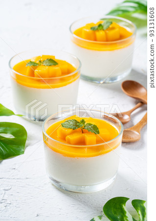 Delicious double colored mango panna cotta mousse pudding on white table background. 93131608