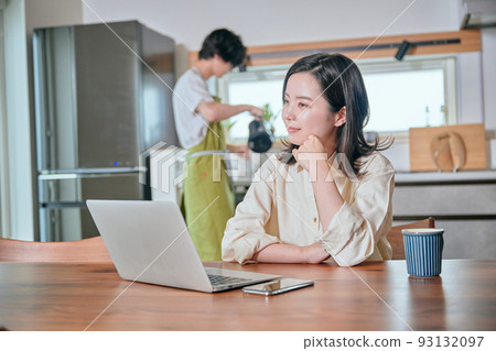 A woman who telework and a man who does housework 93132097