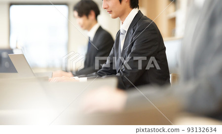 A business person in a suit typing on a PC 93132634