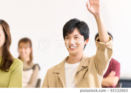 微笑的年輕人舉手在研討會上發言 93132663
