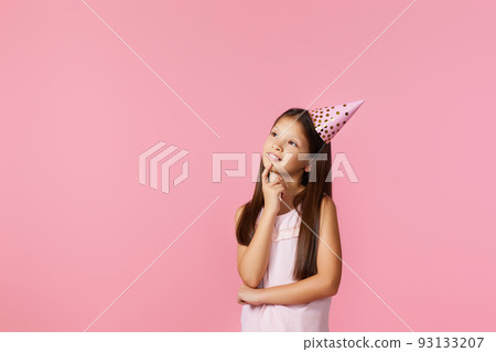 happy little girl with party cone making wish on her birthday happy little girl with party cone making wish on her birthday 93133207