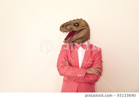 Funny man in dinosaur mask on studio background 93133690