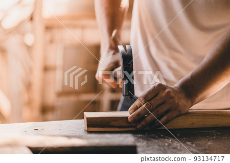 builder wood worker hammer on nails into the wood. construction build renovate and danger at work concept. 93134717