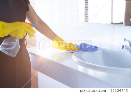 maid cleaning basin sink in public washroom with cloth. clean toilet with glove hygiene home. 93134745