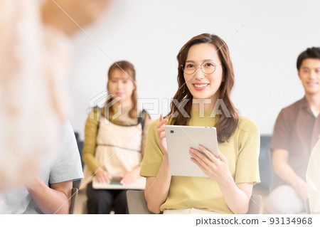 A young woman listening to a seminar lecturer with a smile 93134968