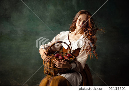 Vintage style. Young charming redhair girl with long curly hair like girl of renaissance eras isolated on dark background. Eras comparison, beauty, art, painting Vintage style. Young charming redhair girl with long curly hair like girl of renaissance eras isolated on dark background. Eras comparison, beauty, art, painting 93135801