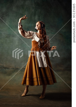 Vintage style. Young charming redhair girl with long curly hair like girl of renaissance eras isolated on dark background. Eras comparison, beauty, art, painting 93135805