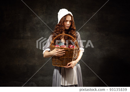 Vintage style. Young charming redhair girl with long curly hair like girl of renaissance eras isolated on dark background. Eras comparison, beauty, art, painting 93135839
