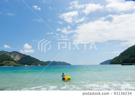 Little girl playing with banana boat on beautiful beach 93136234