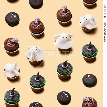 Seamless pattern of Halloween treat maffin decorated ghosts, skeletons, witch hats and macaron with monster faces. Seamless pattern of Halloween treat maffin decorated ghosts, skeletons, witch hats and macaron with monster faces. 93138355