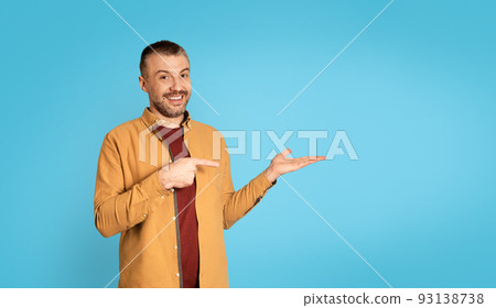 Middle Aged Man Pointing Finger At His Hand, Blue Background Middle Aged Man Pointing Finger At His Hand, Blue Background 93138738