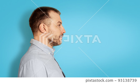 Serious Middle Aged Man Looking Aside, Blue Background, Side View Serious Middle Aged Man Looking Aside, Blue Background, Side View 93138739
