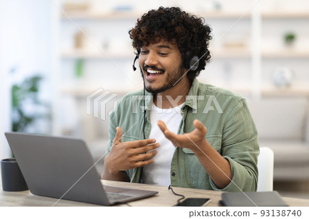 Cheerful handsome indian guy working online, having video conference Cheerful handsome indian guy working online, having video conference 93138740
