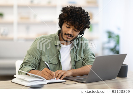Young indian man having online training, home interior Young indian man having online training, home interior 93138809