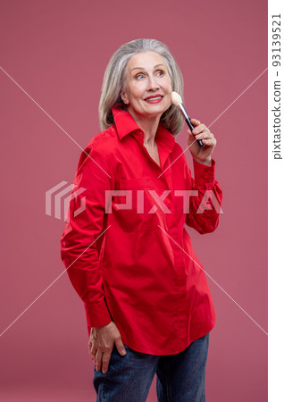 Woman in red with a face brush in hands 93139521