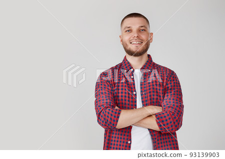 smiling young guy posing with crossed arms 93139903