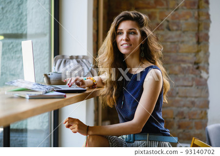 Young attractive woman with a laptop in a coffee shop. 93140702