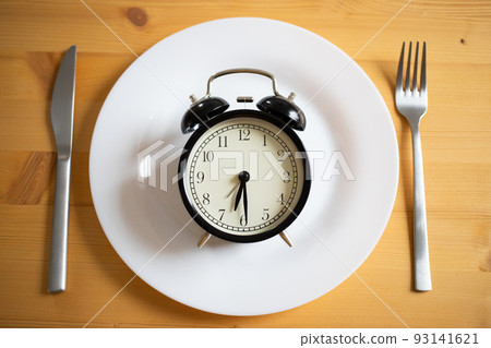 intermittent fasting concept alarm clock on kitchen table intermittent fasting concept alarm clock on kitchen table 93141621