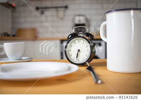 intermittent fasting concept alarm clock on kitchen table 93141626