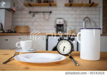 intermittent fasting concept alarm clock on kitchen table intermittent fasting concept alarm clock on kitchen table 93141628