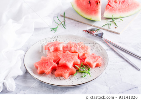 Ripe watermelon stars on a plate on the table. Summer refreshment. 93141826