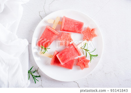 Watermelon popsicle and pieces of watermelon on a plate on the table. Homemade dessert. Top view 93141843