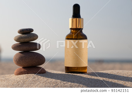 Glass bottle, suntan oil. Natural herbal oil. Golden orange bottle on beach in sand. MOCKUP, Glass bottle, suntan oil. Natural herbal oil. Golden orange bottle on beach in sand. MOCKUP, 93142151