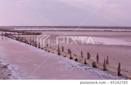 wooden columns covered large lumps of salt in the pink lake. Crimea, Saki 93142785