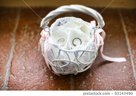 White basket with wedding rings on the table 93143490