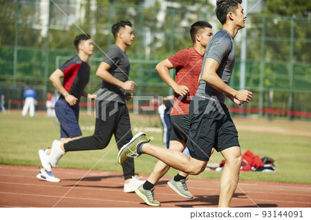 young asian adult athletes running training on track, side view 93144091