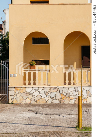 Typical yellow house facade part in italian city near the sea. Mediterranean village style. Typical yellow house facade part in italian city near the sea. Mediterranean village style. 93144462