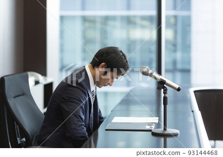 Male businessman in a suit giving an apology press conference Male businessman in a suit giving an apology press conference 93144468