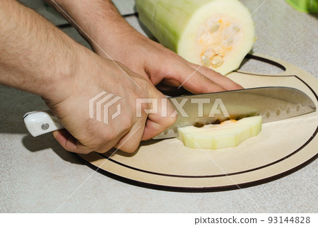 Recipe for zucchini fritters. Step 2 - cutting zucchini. Hands cut green zucchini into cubes. Recipe for zucchini fritters. Step 2 - cutting zucchini. Hands cut green zucchini into cubes. 93144828