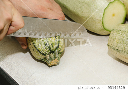 Recipe for zucchini fritters. Step 1 - peeling the zucchini. Hands peel green zucchini Recipe for zucchini fritters. Step 1 - peeling the zucchini. Hands peel green zucchini 93144829