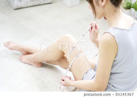 在家用捲尺測量大腿的女人 93145367