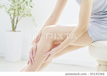 A woman taking care of her calves at home faceless A woman taking care of her calves at home faceless 93145368