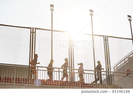 a team of young asian adult men and woman running on top of grand stand in stadium a team of young asian adult men and woman running on top of grand stand in stadium 93146189