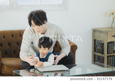 Dad and little boy looking at a computer 93147576