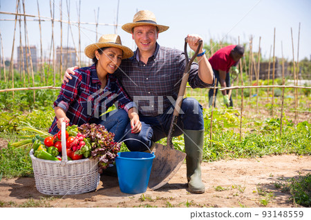 Happy family of gardeners posing with harvest of vegetables 93148559