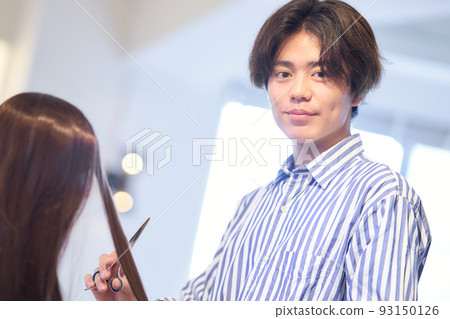 Male hair stylist cutting customer's hair in beauty salon Male hair stylist cutting customer's hair in beauty salon 93150126